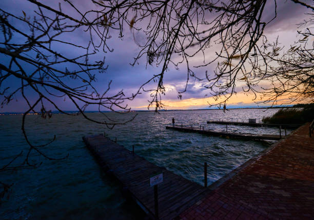 A beautiful sunset over a pier with a sky full of clouds.