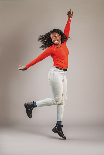 Happy and Confident Woman Jumping In The Studio