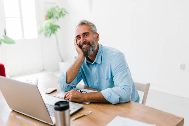 istock Smiling senior businessman working at office 1456636676