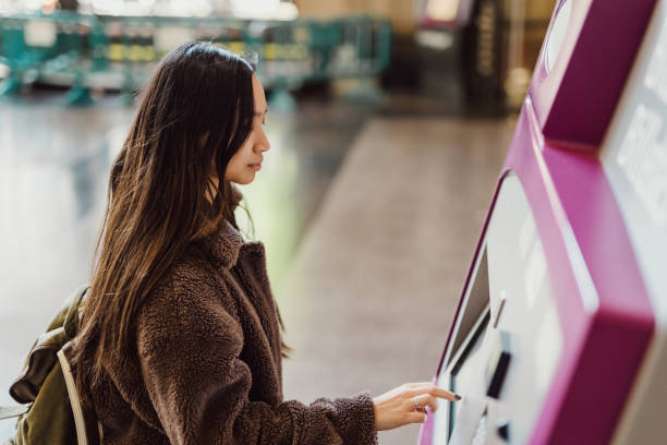 istock Asian woman using ATM machine at train station 1456641105
