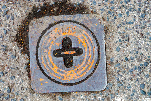 Manhole cover of the gas pipeline system. A massive metal hatch for access to city communications in the pavement.
