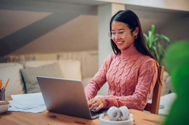 istock Vietnamese Asian woman using laptop while working at home 1456643920