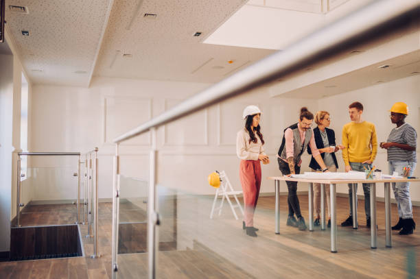 istock Multiracial team of architects having a meeting while using blueprints 1456643924