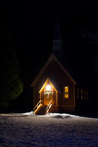 The Yosemite Valley Chapel, in the middle of the night, illuminated only by the porch and interior lights.