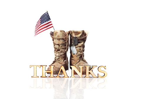 Word THANKS and old military combat boots with a small American flag