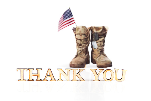 Text THANK YOU and old military combat boots with a small American flag