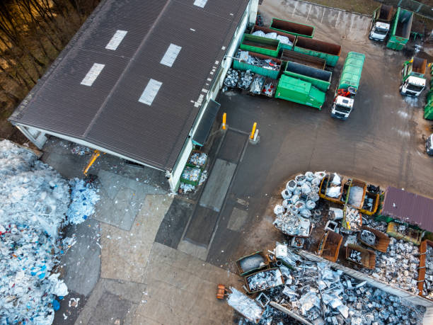 Municipal recycling center with empty garbage containers and trucks, aerial view