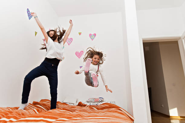istock Young Girls Jumping on bed 1456650681