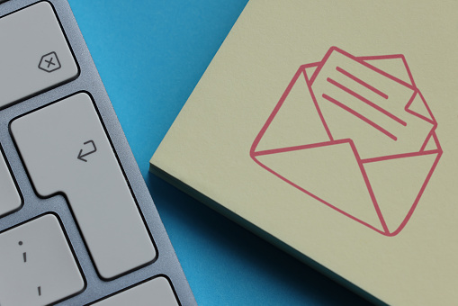 Envelope icon on adhesive note paper with computer keyboard