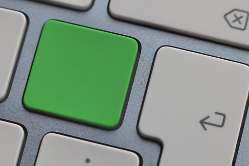 Close up computer keyboard with green push button