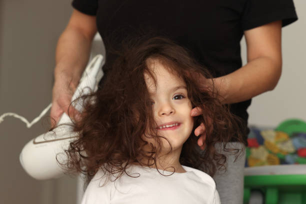 mère séchant les cheveux d’une petite fille - brushing teeth photos et images de collection