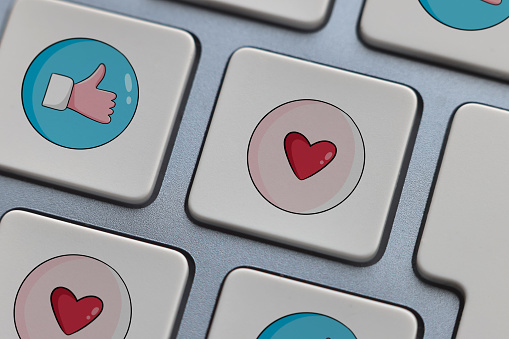 Thumbs up and heart shape icons on computer keyboard