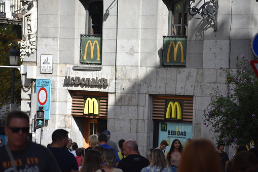 McDonald's Corporation American multinational fast food chain in Madrid, Spain with locals and tourists walking in European urban streets