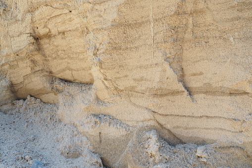 Sandstone is a fragmentary sedimentary rock, a homogeneous or layered aggregate of fragmentary grains and grains of sand bound by any mineral substance, cement. Quarry natural yellow sand wall