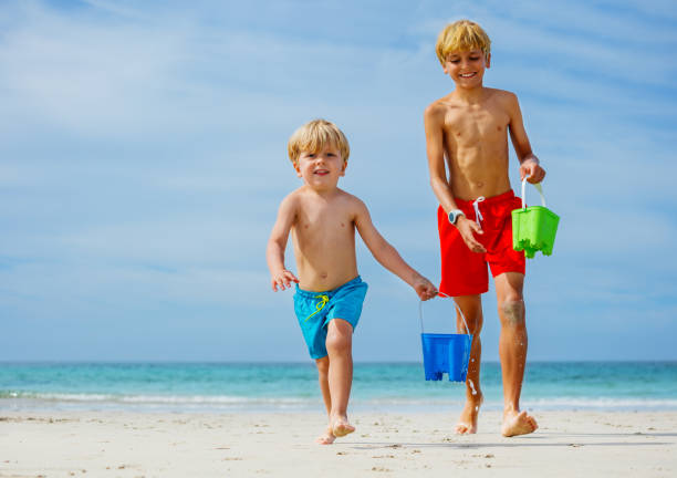 Little boy and girl building a sandcastle on the beach  in summer