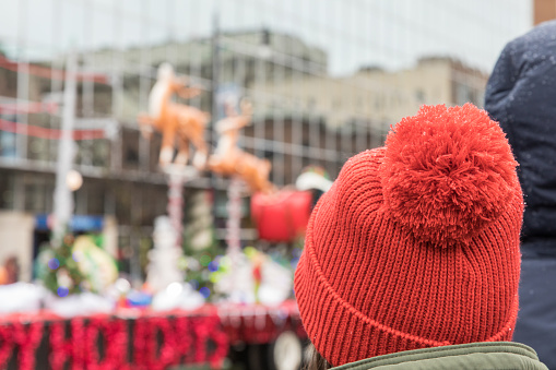 A woman watching a float in a Christmas parade