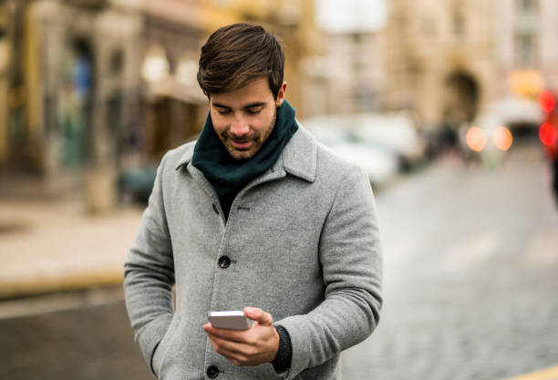 istock Young man using phone on the street. 1456665050