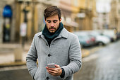 Young man using phone on the street.