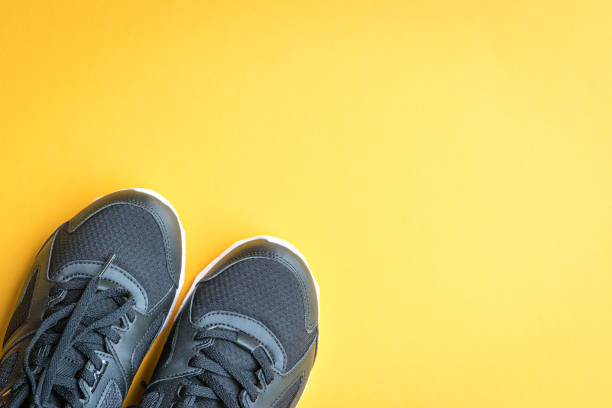 istock Black sport shoes on yellow background. 1456668701