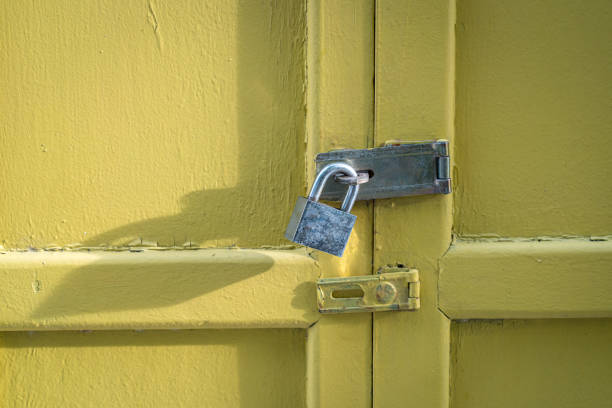 istock Yellow wood door closed with padlock. 1456668705