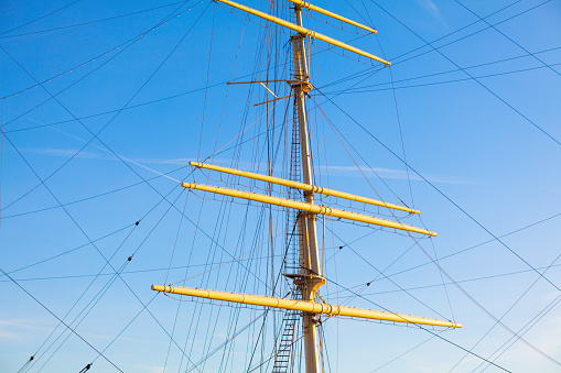 Masts with lowered sails . Nautical masts against sky