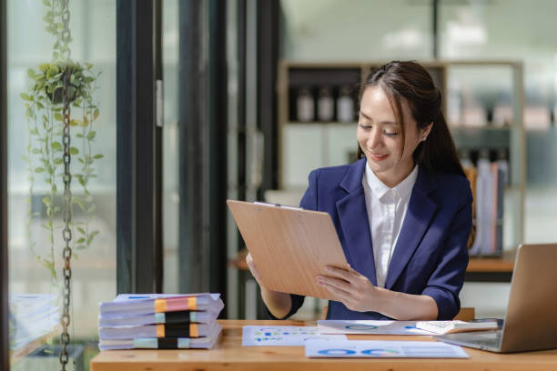 istock Asian businesswoman working with laptop computer and calculator financial documents on table make a plan analyzing financial reports business plan investment in the office 1456675508