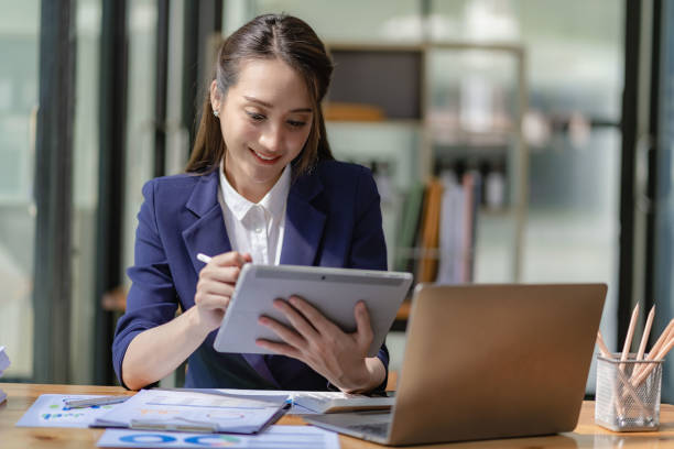 istock Asian businesswoman working with laptop computer and calculator financial documents on table make a plan analyzing financial reports business plan investment in the office 1456675512
