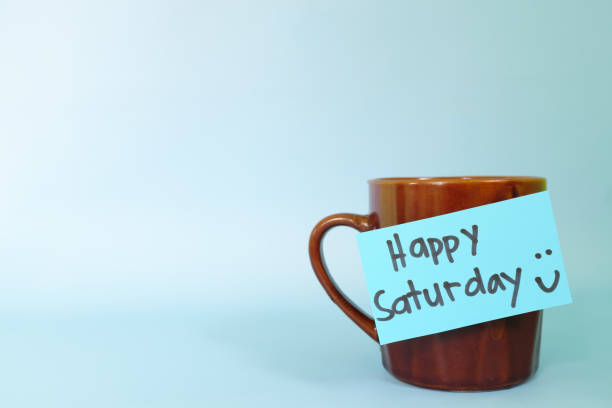istock Welcome, hello and happy Saturday concept. Selective focus of coffee cup with written message isolated in blue background. 1456686981