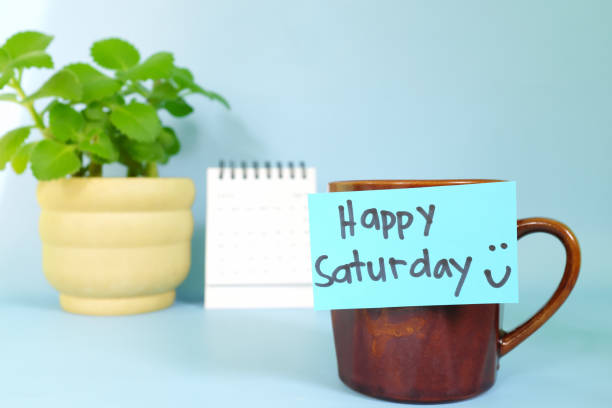 istock Welcome, hello and happy Saturday concept. Selective focus of coffee cup with blue paper note and written message. 1456686986