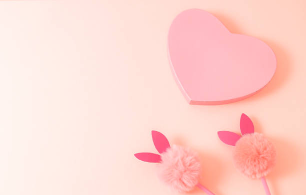 istock Gift box with a heart and a bunny handle on a naturally beige background. 1456688433
