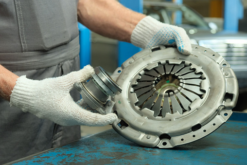 In the hands of an auto mechanic, the leading and driven discs, the exhaust bearing.Replacement of the clutch in the service station.