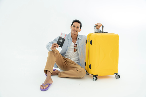 Photo of Asian men with their suitcases with passports and travel tickets. isolated on a white background