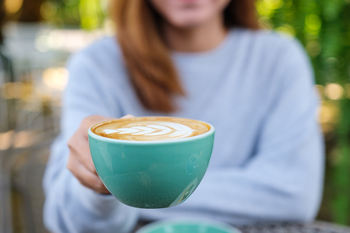 Closeup image of a woman holding a hot coffee cup