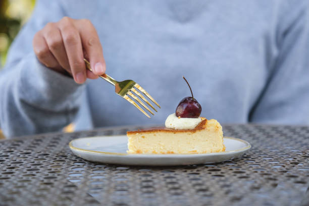 Closeup image of a woman eating cheesecake with fork