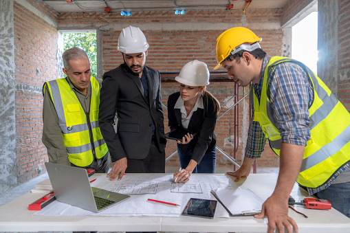 The engineer talks to the contractor to supervise and plan the work.