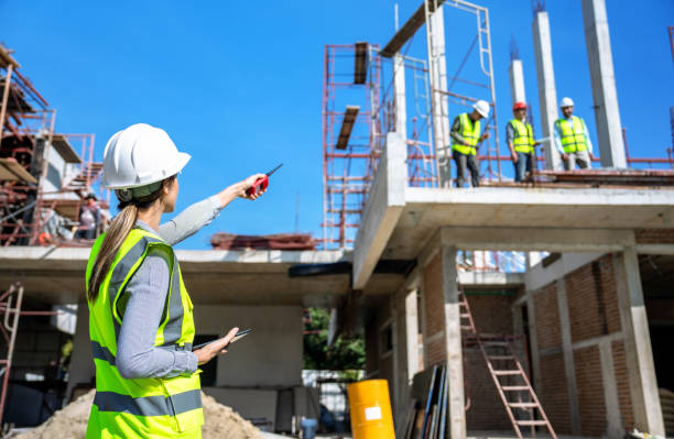 the engineer talks to the contractor to supervise and plan the work. - dirigindo imagens e fotografias de stock