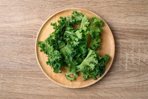istock Sliced Green Kale or leaf cabbage on wooden plate, Healthy vegetable, Table top view 1456700984