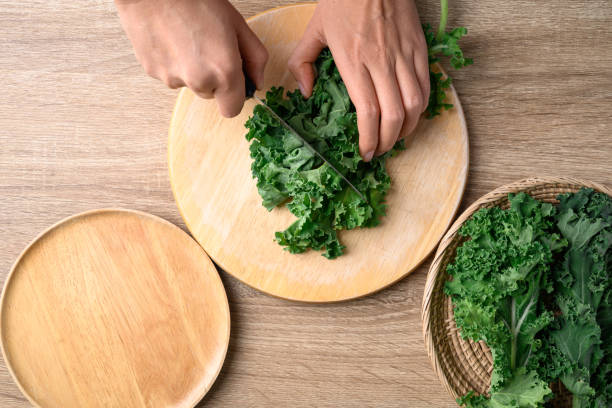 istock Green Kale or leaf cabbage cutting on wooden board, Healthy vegetable, Table top view 1456700986