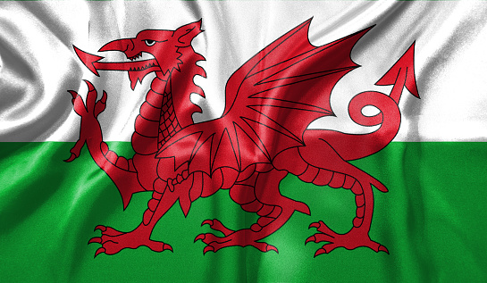 Wales flag wave close up. Full page Wales flying flag. Highly detailed realistic 3D rendering.