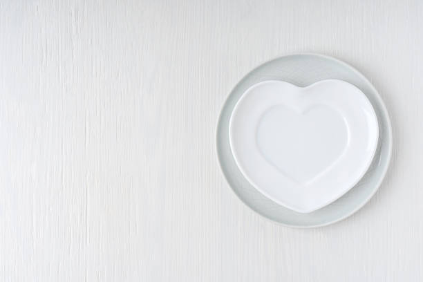 istock Top view of empty heart shaped plate served on white wooden background with copy space 1456710537