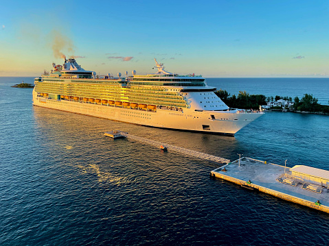 Nassau, Bahamas - January 3, 2023: Royal Caribbean International’s “Independence of the Seas” cruise ship backs out of Nassau Harbor at sunset.
