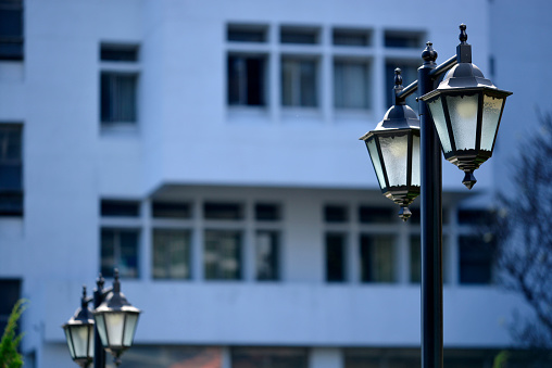 An ancient lamppost with blur building background