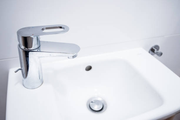 istock Open chrome faucet, tap washbasin in light room 1456711938