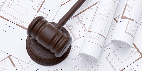 Construction and Labor Law. Wooden judge gavel on building blueprint plan background. Brown color hammer on opened and roll draft. Above view. 3d render