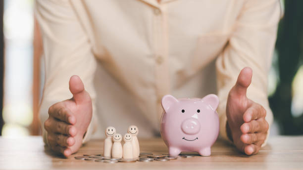 Men show protection and safety protection to wooden dolls and piggy banks , The concept of insurance management planning, for both health and financial safety Reduce risks to property and family los hombres muestran protección y protección de seguridad a muñecas de madera y alcancías , el concepto de planificación de la gestión de seguros, tanto para la salud como para la seguridad financiera reducir los riesgos para la propiedad y la famili