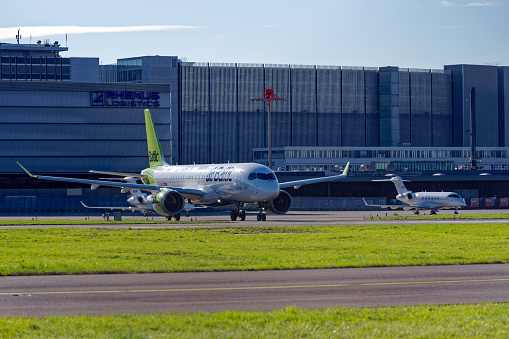 White and green Air Baltic airplane Airbus A220-300 register YL-ABG taxing to runway on a sunny autumn day. Photo taken November 23rd, 2022, Zürich, Switzerland.