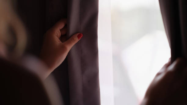 istock Female hands opens curtains in a dark bedroom 1456718379