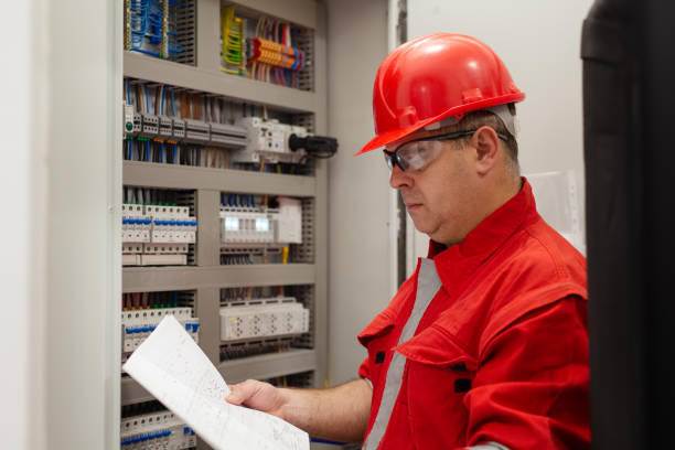 istock Electrician looking at plans for power junction box 1456720268