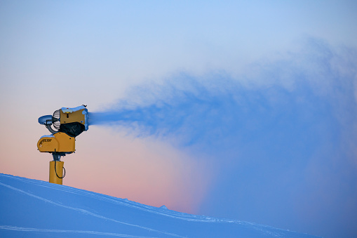 Snow making machine, named snow cannon or snow gun making snow for snowboarding, skiing in mountains.