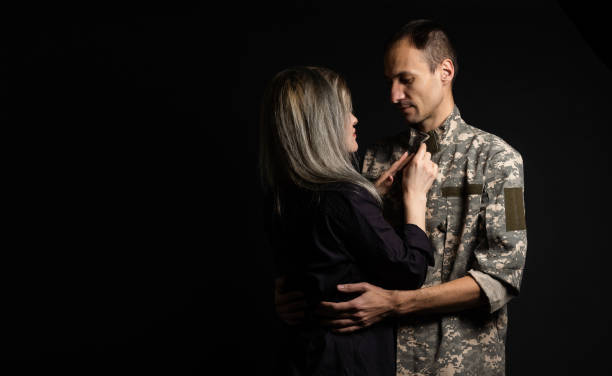 military man and his wife on a black background.